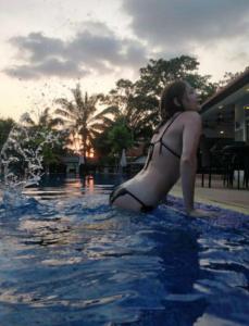 Luxury 250sqm Pool Villa in Central Location 5min to Beach & Walking Street! في باتايا سنترال: وجود امرأة بملابس السباحة في المسبح