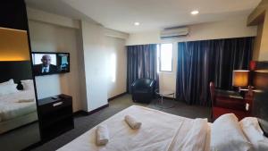 a hotel room with a bed and a flat screen tv at SUN GARDEN Studio and Residences at South China Sea Place Suites in Kota Kinabalu