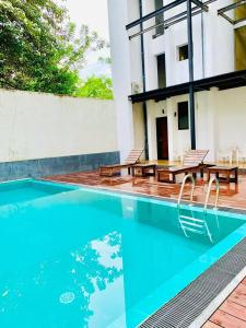 a house with a swimming pool and two chairs at Kandyan View Holiday Bungalow ''Free Pickup From Kandy city'' in Kandy