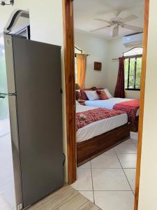 1 Schlafzimmer mit 2 Betten und einem Kühlschrank in der Unterkunft Enchanted Monkey Apartment in Quepos