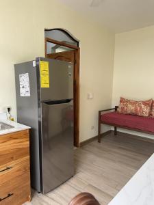 eine Küche mit einem Kühlschrank und einer roten Bank in der Unterkunft Enchanted Monkey Apartment in Quepos