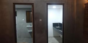 ein Badezimmer mit einem Waschbecken, einem WC und einem Spiegel in der Unterkunft Habarana Farm Cottage in Avudangawa