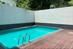 una piscina con due maniglioni di metallo in una recinzione di Kandyan View Holiday Bungalow ''Free Pickup From Kandy city'' a Kandy