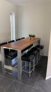 une table en bois entourée de chaises noires dans l'établissement Villa Riverside met hottub, eigen aanlegsteiger, zwemtrap, trampoline en kano's, à Zeewolde 34 autres photos