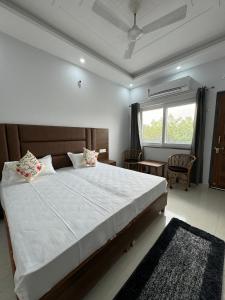 a bedroom with a large bed and a window at Hotel Yog Vriksh in Rishīkesh