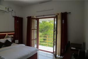 a bedroom with a bed and a sliding glass door at raison d'être - The Residential Library in Trivandrum