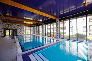 - une grande piscine dans un bâtiment doté de fenêtres dans l'établissement Apartament Premium '5 Mórz', à Sianożęty