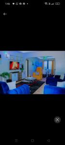 a living room with a blue couch and a living room with a couch at Greenstar home in Kisii