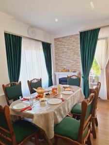 a dining room with a table and green chairs at Pensiunea Casa Ancuta in Vadu Izei