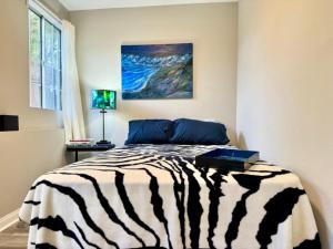 een slaapkamer met een bed met een zebradeken bij #Universal in Los Angeles