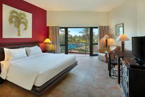 a hotel room with a bed and a television at Manado Tateli Resort and Convention in Manado