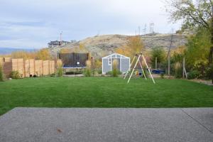 a yard with a swing set in the grass at Your Cozy Retreat, 2BR suite in Kamloops