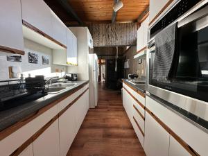 cocina con armarios blancos y techo de madera en The Cabin in Packwood, en Packwood