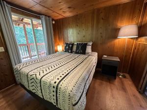 een slaapkamer met een bed in een kamer met een raam bij The Cabin in Packwood in Packwood