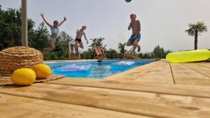 een groep mensen die in een zwembad springen bij Villa Natanebi 