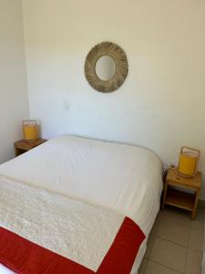 a bedroom with a bed and a mirror on the wall at Rez de Jardin Piscine et Plage in Poggio-Mezzana