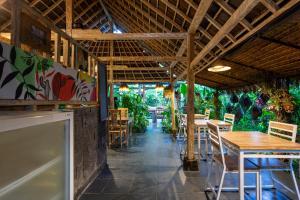 a restaurant with wooden tables and chairs and plants at Abipraya Ubud in Ubud