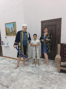 een man en een vrouw en een kind in een kamer bij Mubina Khiva B&B in Khiva