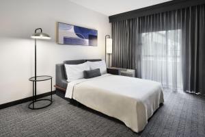 a hotel room with a bed and a chair at Courtyard by Marriott Atlanta Duluth/ Gwinnett Place in Duluth