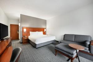 a hotel room with a bed and a tv at Courtyard by Marriott Atlanta Duluth/ Gwinnett Place in Duluth