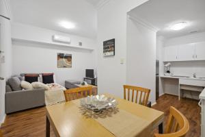 sala de estar con mesa y sofá en 1BDR 1BTH 1PRK - James Street Joy, en Perth