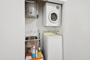 una pequeña cocina con lavadora y fregadero en 1BDR 1BTH 1PRK - James Street Joy, en Perth