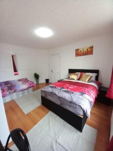 1 dormitorio con 1 cama grande en una habitación en JosteeStay Apartments -Rooms en Goodmayes