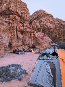 una tenda sulla sabbia di fronte a una montagna di The Rock Camp a Wadi Rum