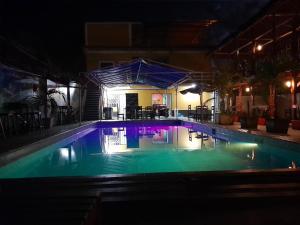 a swimming pool at night with lights on at El Bunker 9 in Iquitos
