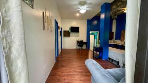 un soggiorno con pareti blu e divano di Ngermid Oasis - Vibrant 2 BD/1 BA Duplex a Ngermid