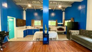 salon z niebieskimi ścianami, stołem i kanapą w obiekcie Ngermid Oasis - Vibrant 2 BD/1 BA Duplex w mieście Ngermid