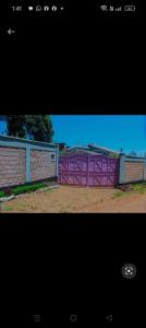 a purple fence in front of a building at Greenstar home in Kisii