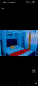 een slaapkamer met een bed met een rode deken bij Greenstar home in Kisii