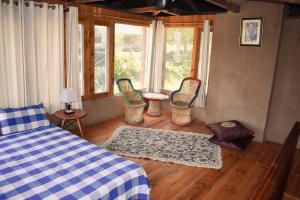 sypialnia z łóżkiem, krzesłami i stołem w obiekcie The Shivdhaar Estate Patnitop w mieście Kūd