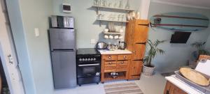a kitchen with a stove and a refrigerator at Baggies Inn in Umkomaas