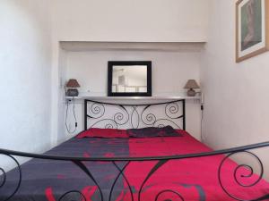 Schlafzimmer mit einem roten Bett und einem Spiegel an der Wand in der Unterkunft Maison,Gite 8 places in Rivières