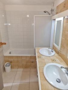 ein Badezimmer mit 2 Waschbecken, einer Dusche und einer Badewanne in der Unterkunft Maison,Gite 8 places in Rivières