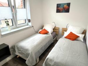 a bedroom with two beds and a window at Ferienhaus "Elstar" Meppen Ebenerdig Carport Terrasse Neubau NETFLIX Free WIFI 2 Schlafzimmer Küche in Meppen +41 photos