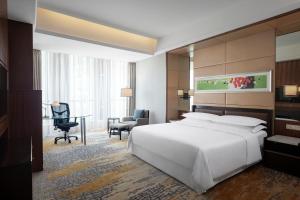 1 dormitorio con 1 cama blanca grande y escritorio en Sheraton Grand Shanghai Pudong Hotel & Residences, en Shanghái