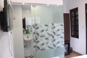 y baño con ducha, aseo y lavamanos. en Hanoi Little Hotel, en Hanói