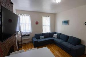 a living room with a blue couch and a tv at Comfortable 1-Bedroom Apt in Manhattan in New York