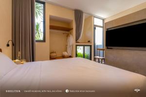 1 dormitorio con 1 cama grande y TV grande en Shelter Stay Da Nang, en Da Nang