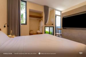 a bedroom with a large bed and a large television at Shelter Stay Da Nang in Da Nang