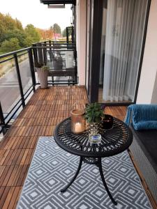 a table on a balcony with a plant on it at Apartament z widokiem Łańcut in Łańcut