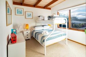 a bedroom with a bunk bed and a window at Coota Views in Mallacoota
