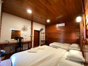 Un dormitorio con dos camas y un escritorio. en Letana Guesthouse, en Ban O 29 fotos más