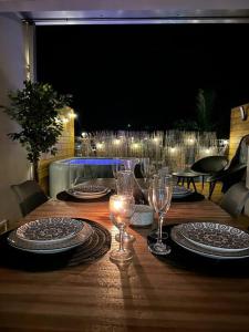 een houten tafel met borden en wijnglazen erop bij La villa luna and spa in La Possession