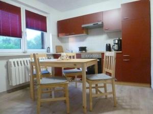 Una cocina con una mesa de madera y dos sillas. en Seeschwalbe Comfortable holiday residence, en Dranske