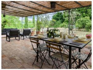 a patio with a table and chairs on a patio at Villa Fienile Design in SantʼAppiano