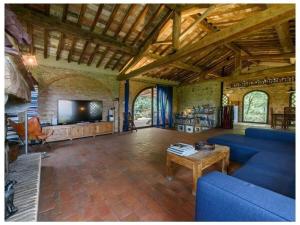 un grand salon avec un canapé bleu et une télévision dans l'établissement Villa Fienile Design, à SantʼAppiano